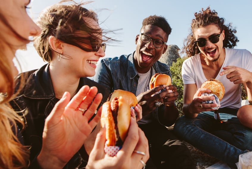 Group of Friends Eating Burger on Mountain Top